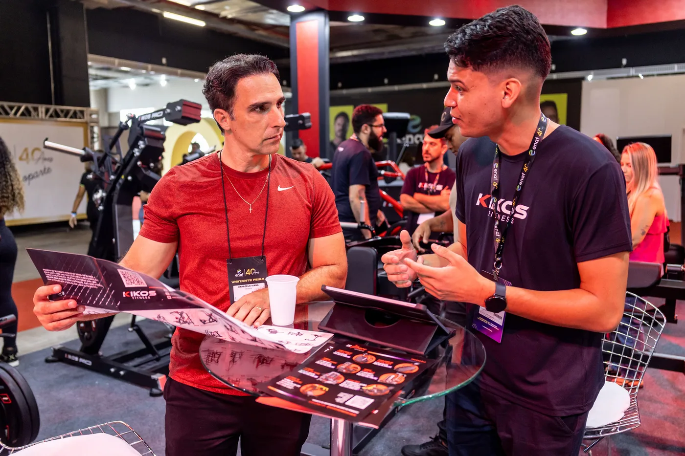 Expositor apresentando catálogo de equipamentos a um visitante no ENAF
